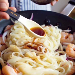 うどんはレンジで解凍して加える。麺の上に調味料を回しかけるとほぐれやすく、手早く炒め合わせることができる。