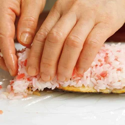 さばの形を生かしてご飯を横長に広げる。はみ出したご飯は上にのせて軽く押さえ、棒状に形を整える。