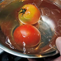トマトはうまみを逃がさないよう、へたを取らずにそのままで湯むきして。