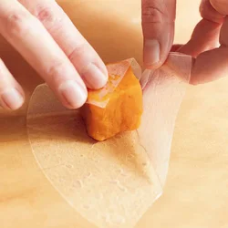 かぼちゃを中央に置き、もどしたライスペーパーを側面に張りつけるようにしながら、すっぽりと包む。