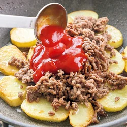 じゃがいもの上にひき肉を戻し入れたら、調味料を加えて味つけする。