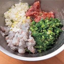 ひき肉に調味料を加えてよく練り混ぜてから、春菊、えび、長ねぎを加えてさらに混ぜる。春菊はしっかり水けを絞ってから加える。