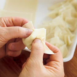 ワンタンの皮は半分に折ったら両側にひだを寄せて。