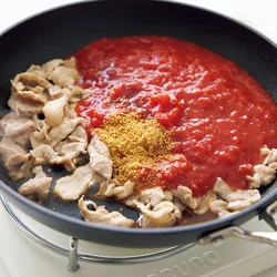 豚こまを焼いてトマトを加え