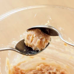 肉だねはスプーン2本を使い、丸く形づくってから、鍋に落とす。