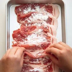 豚肉に小麦粉をまぶす