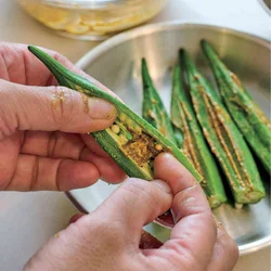 オクラの種を潰すようにしてスペースを作り、指でカレーマヨをぬる。