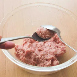 肉だねはスプーン2本を使い、丸く形づくってから、鍋に落とす。