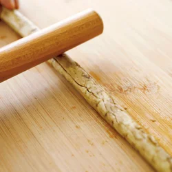 味がよくしみこむように、めん棒でひびが入るくらいまで全体をたたいてから切り分ける。